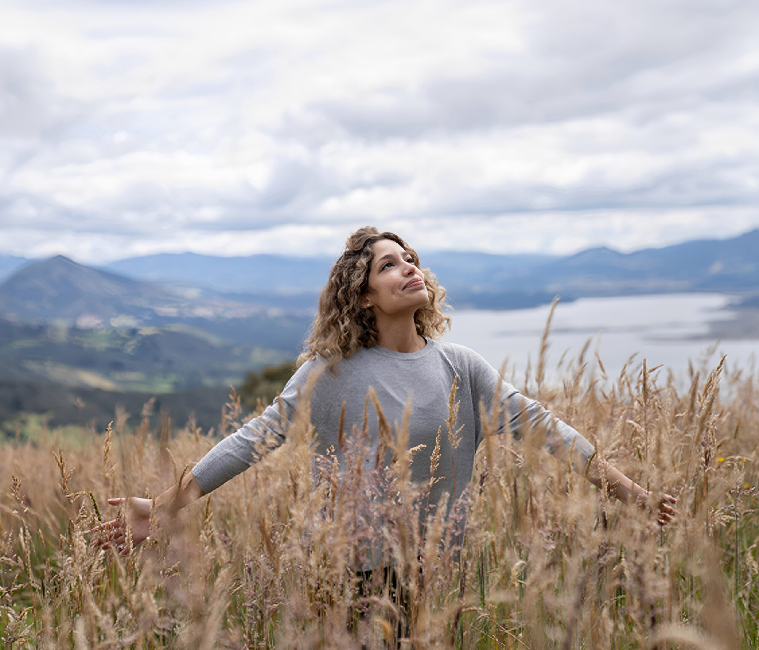 Woman enjoying nature in grassy field.