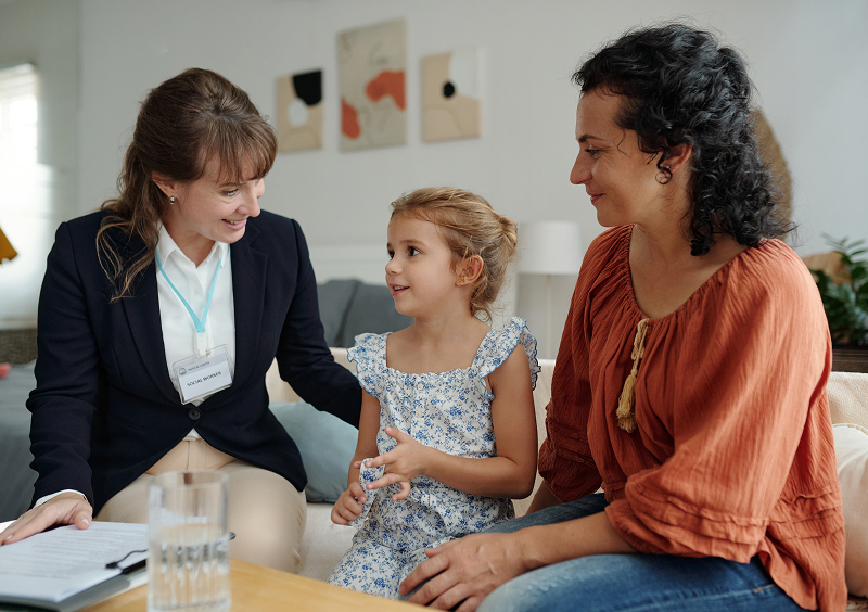 Woman, child, and professional having a conversation.