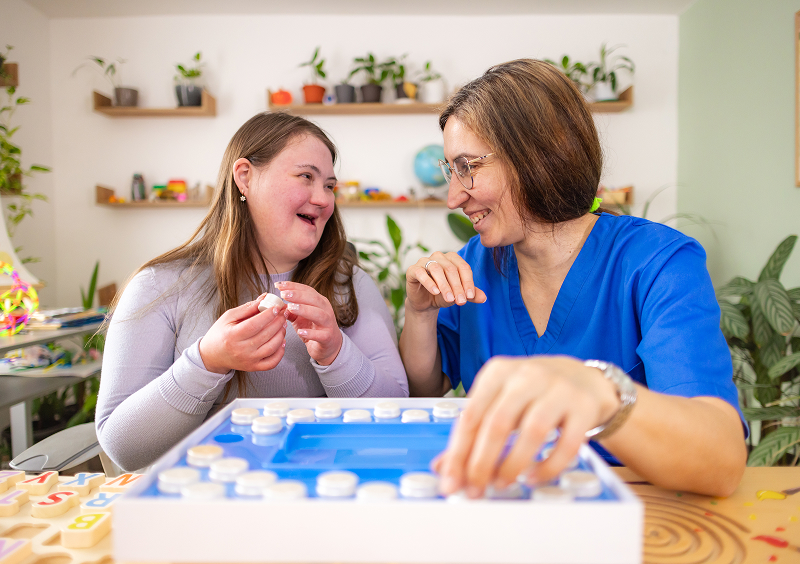 Woman and girl smiling while playing game.