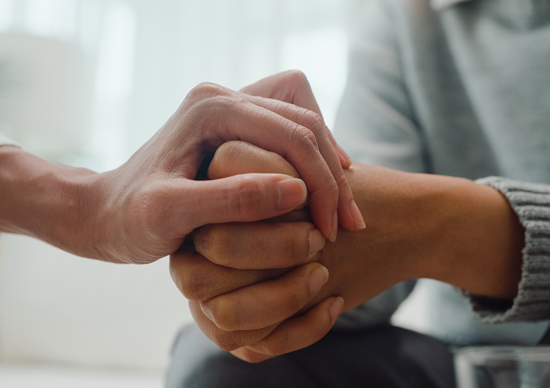Hands holding each other in support.